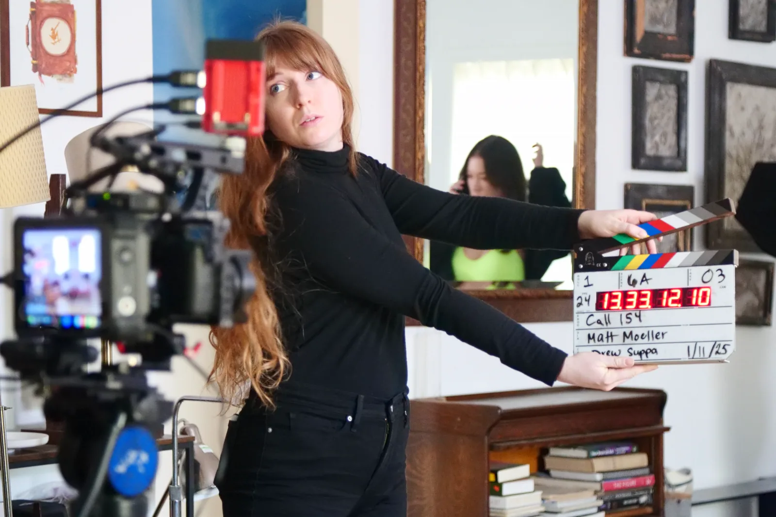 A crew member holding the Call 154 slate in front of the camera