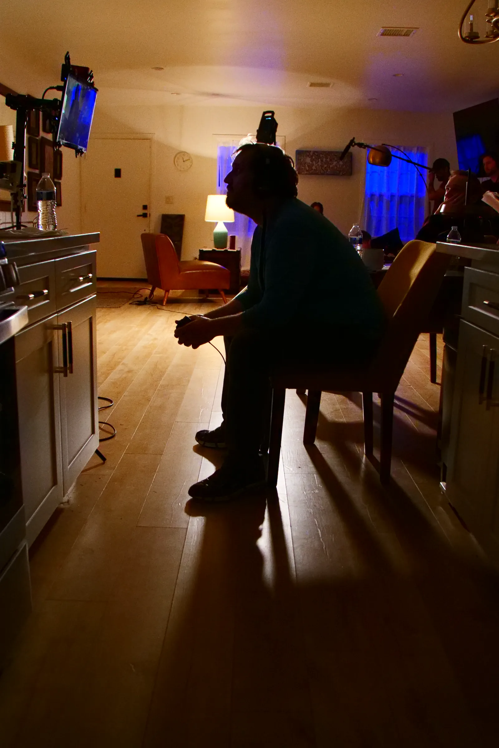A crew member in silhouette in the darkened apartment