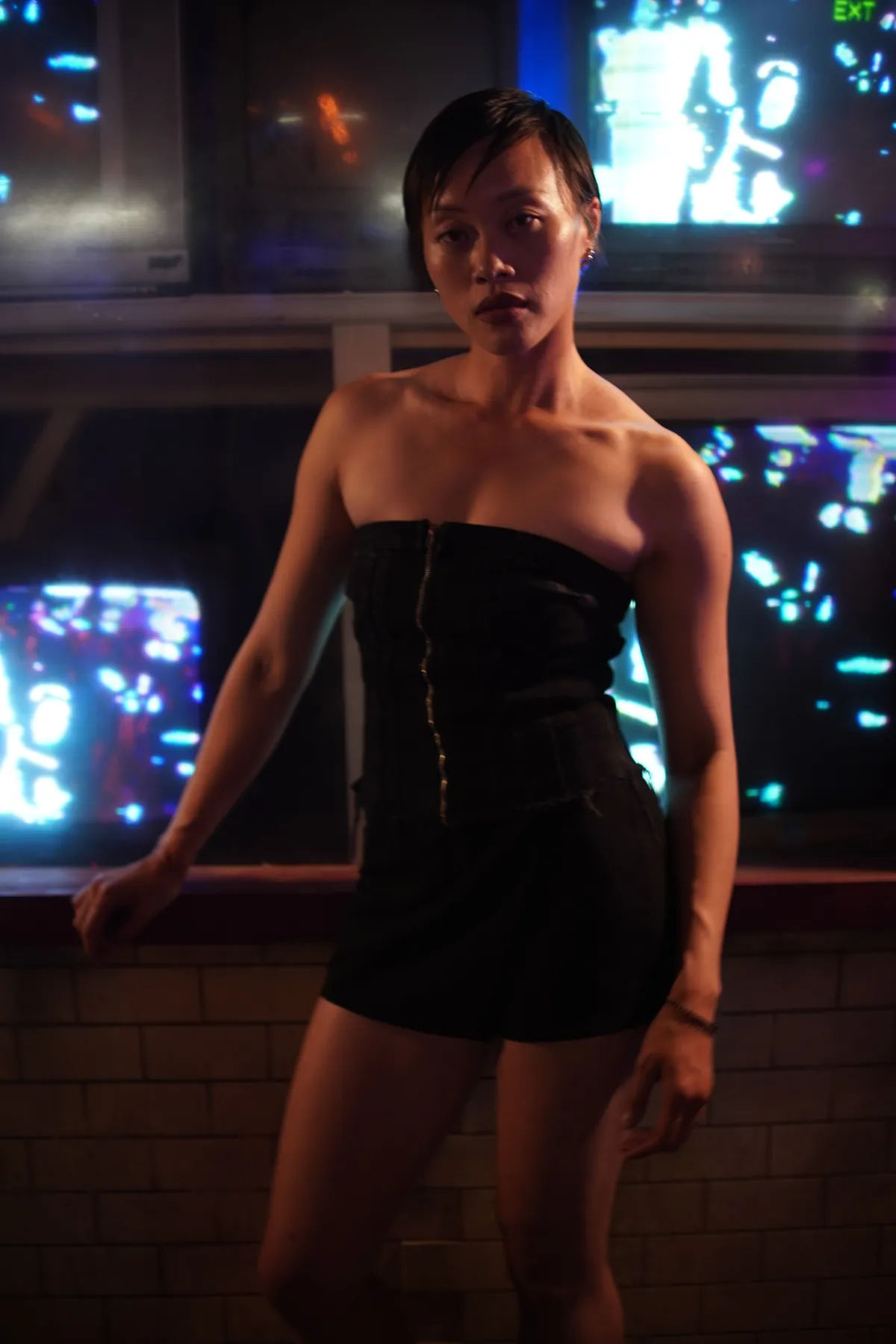 Portrait in a black dress surrounded by arcade lights