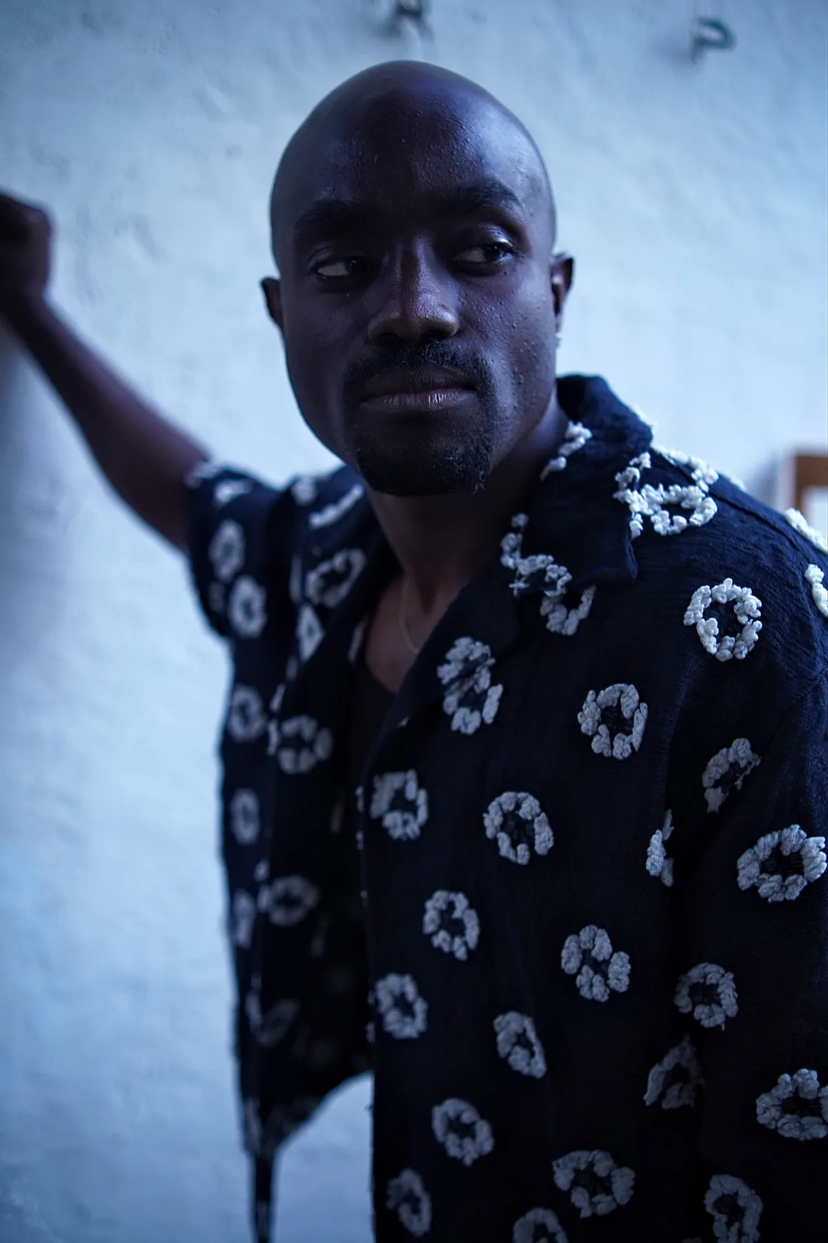 Blue-lit portrait in a patterned shirt