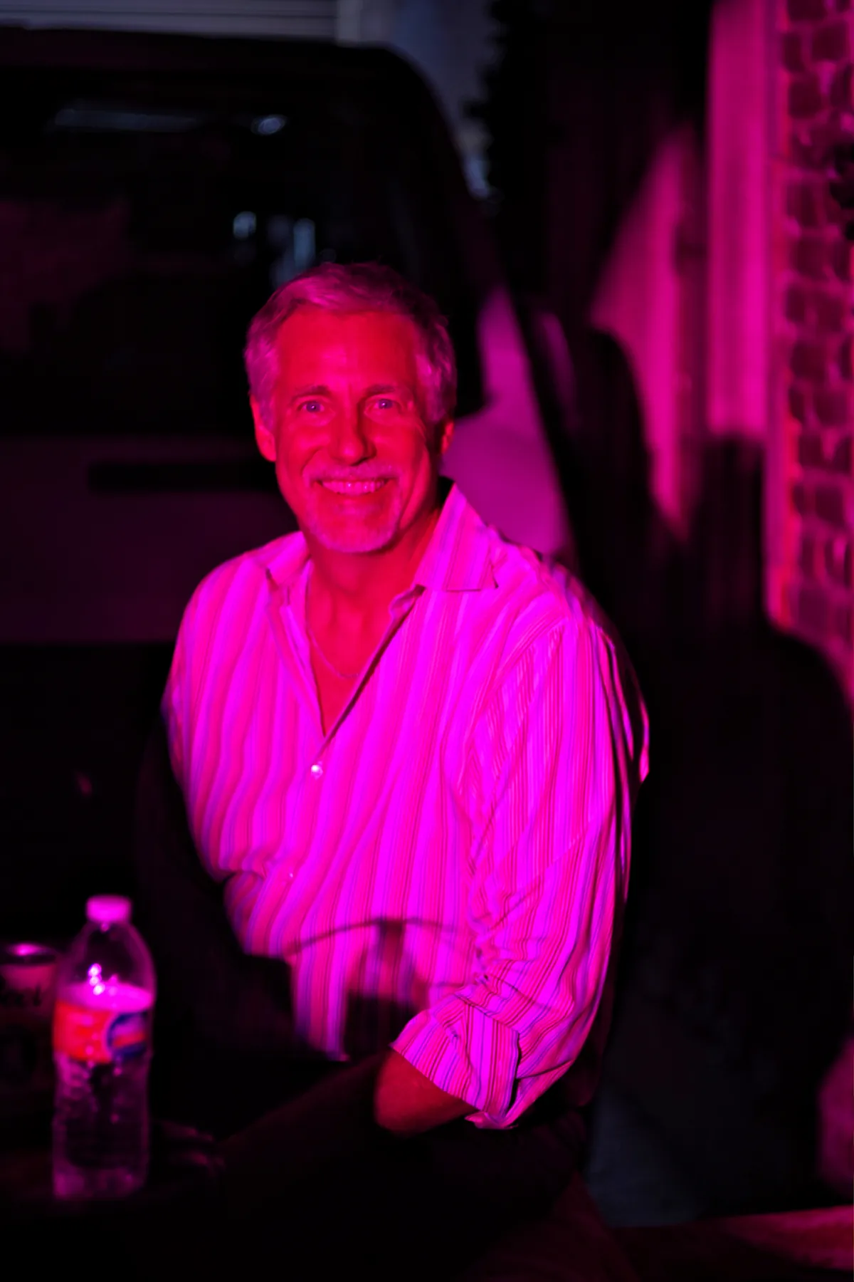 Magenta-lit portrait at a nighttime event